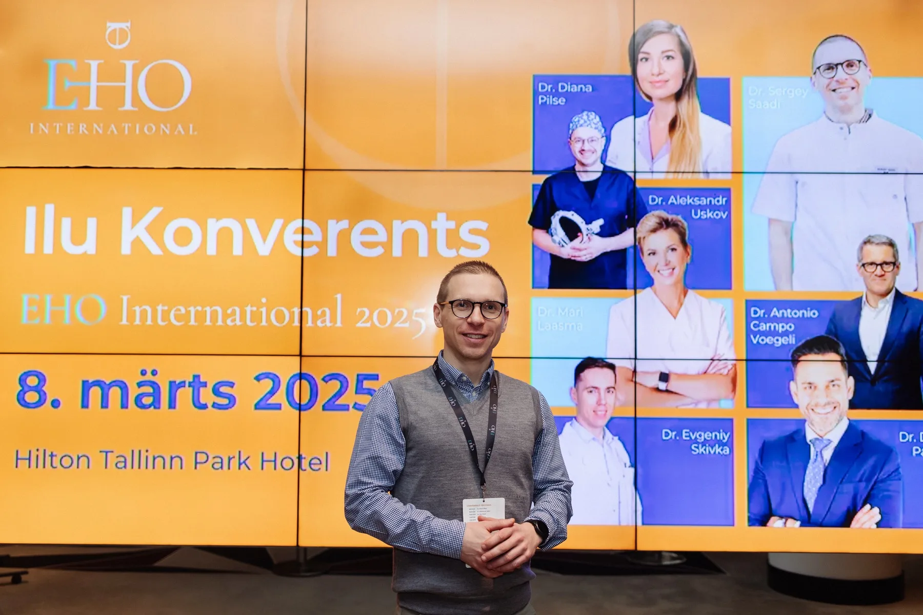 Guest portrait in front of the EHO conference wall