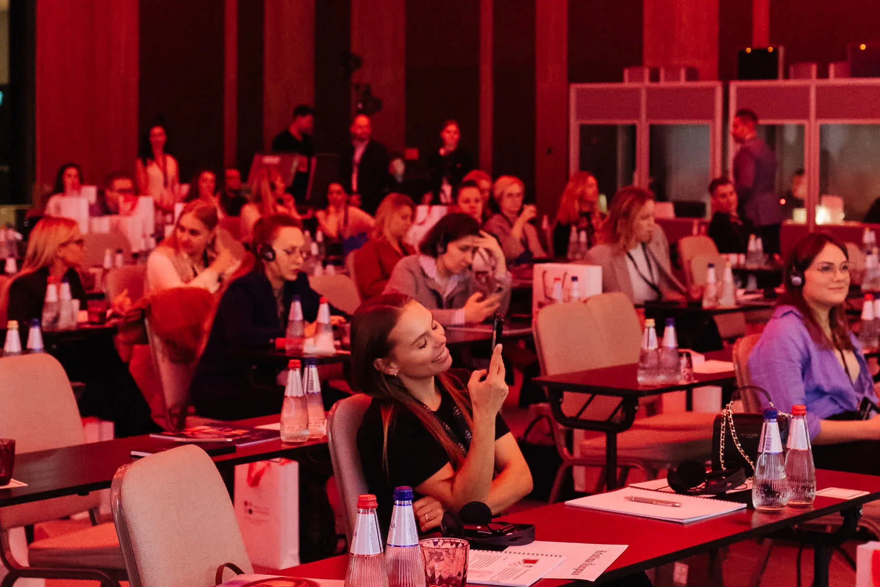 Audience watching an EHO International session with red stage lighting