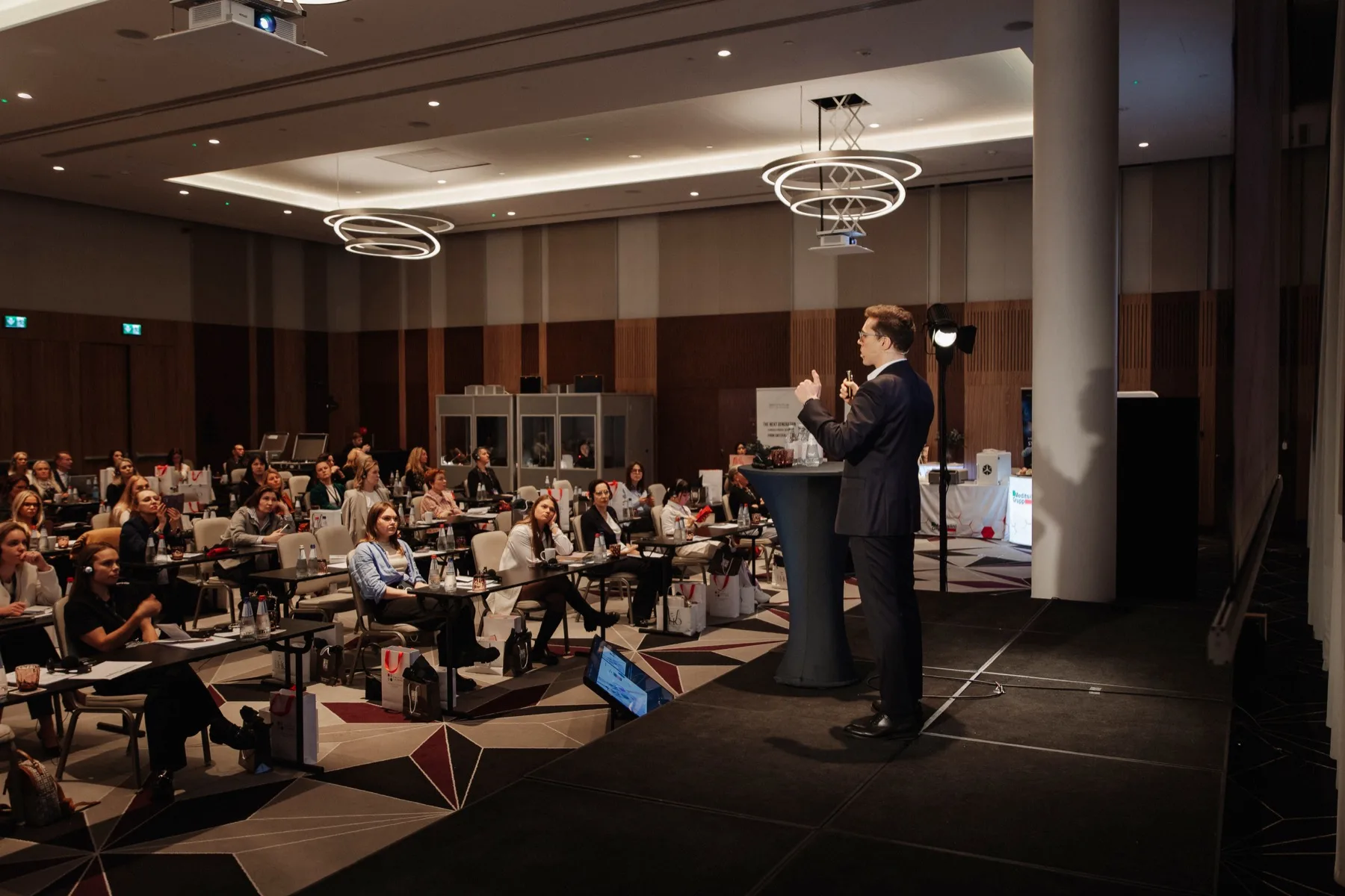 Speaker presenting aesthetic medicine topics on stage